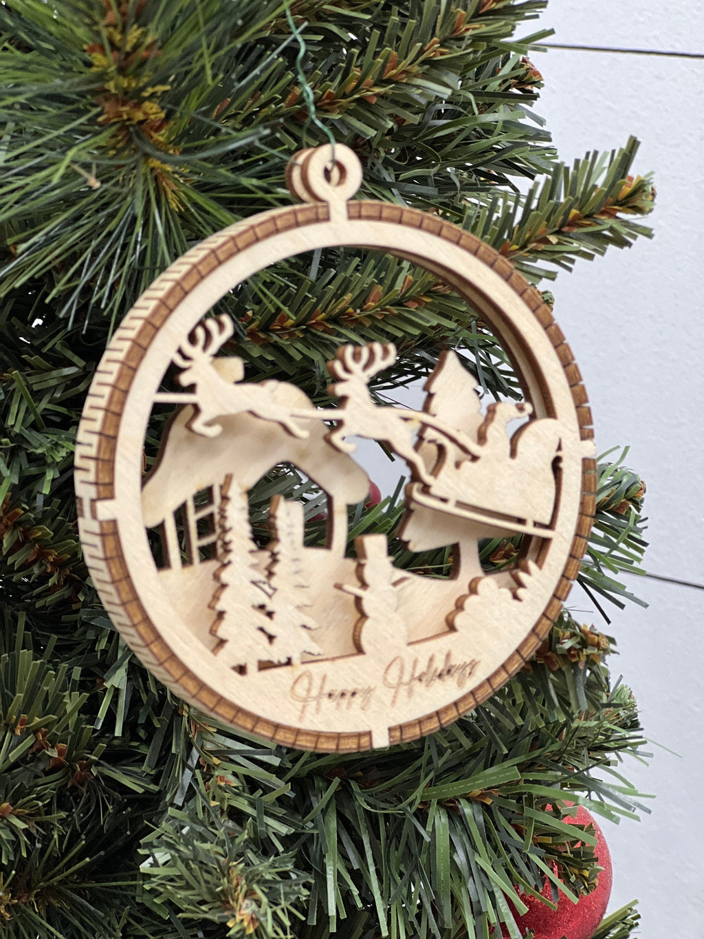 This is a round wooden Christmas ornament with a winter scene with a living hinge. It’s Santa on his midnight run.