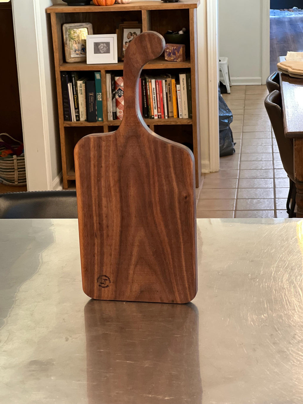 This is a handmade, solid wood walnut , custom design handle cutting board. The dimensions of this board are 17”x7 1/2”x3/4”.