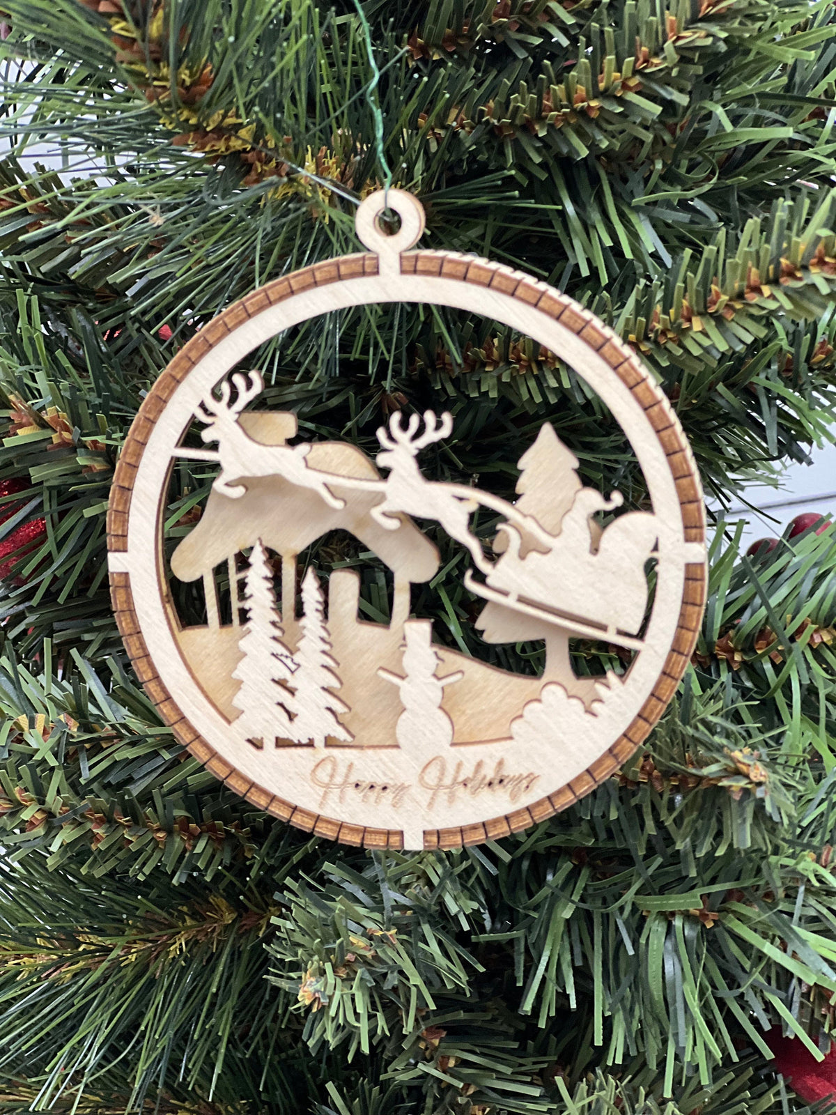 This is a round wooden Christmas ornament with a winter scene with a living hinge. It’s Santa on his midnight run.