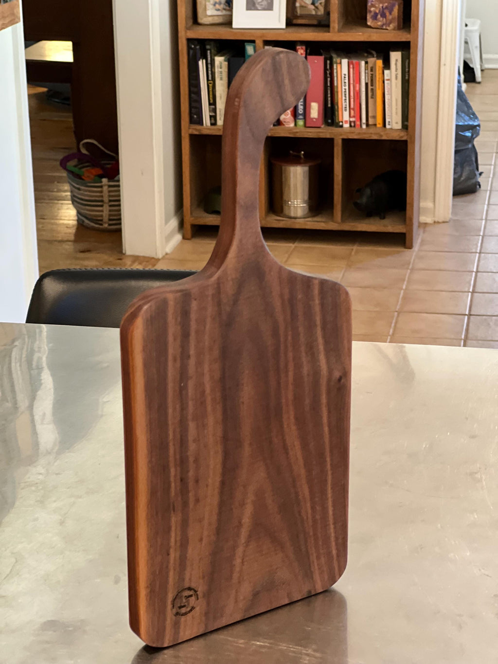 This is a handmade, solid wood walnut , custom design handle cutting board. The dimensions of this board are 17”x7 1/2”x3/4”.