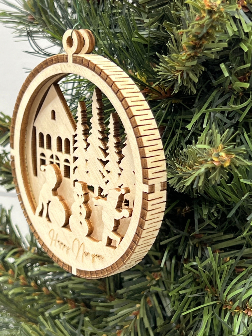 This is a round wooden Christmas ornament with a winter scene with a living hinge. It shows the kids having fun playing in the snow.