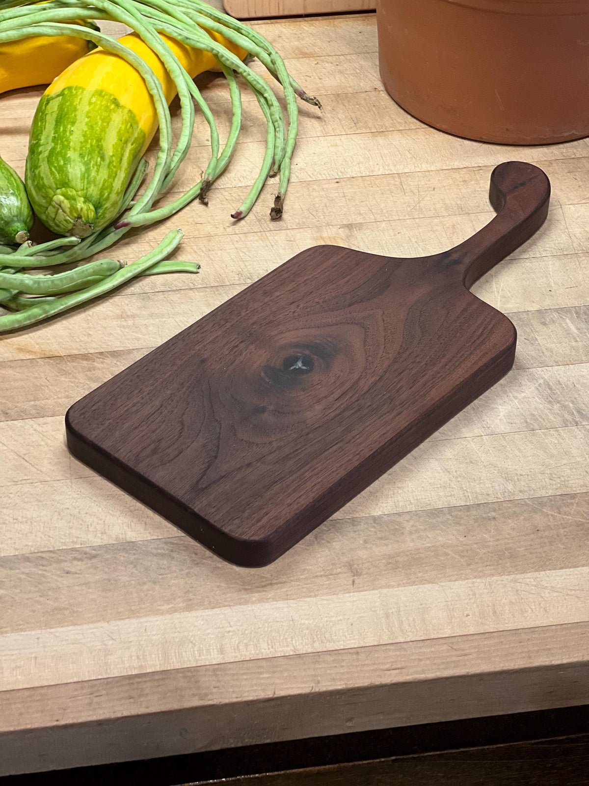 This is a handmade, solid wood walnut , custom design handle cutting board. The dimensions of this board are 17”x7 1/2”x3/4”.