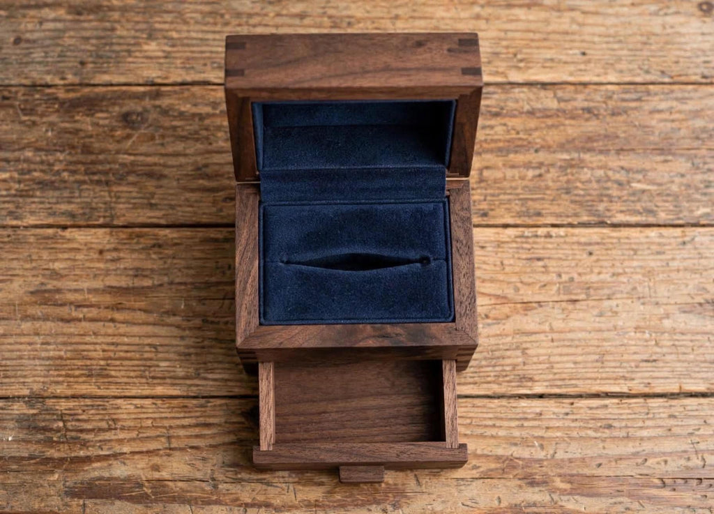 Classic craftsman style — lift-top ring section with a pull-out drawer underneath for the second band, notes, or keepsake