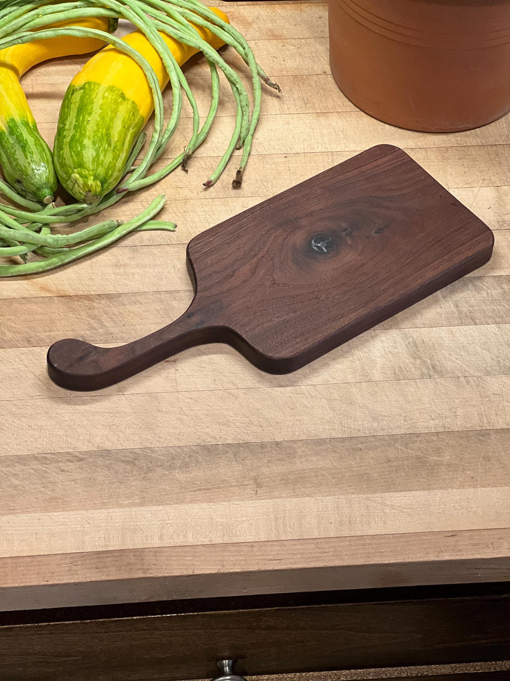 This is a handmade, solid wood walnut , custom design handle cutting board. The dimensions of this board are 17”x7 1/2”x3/4”.