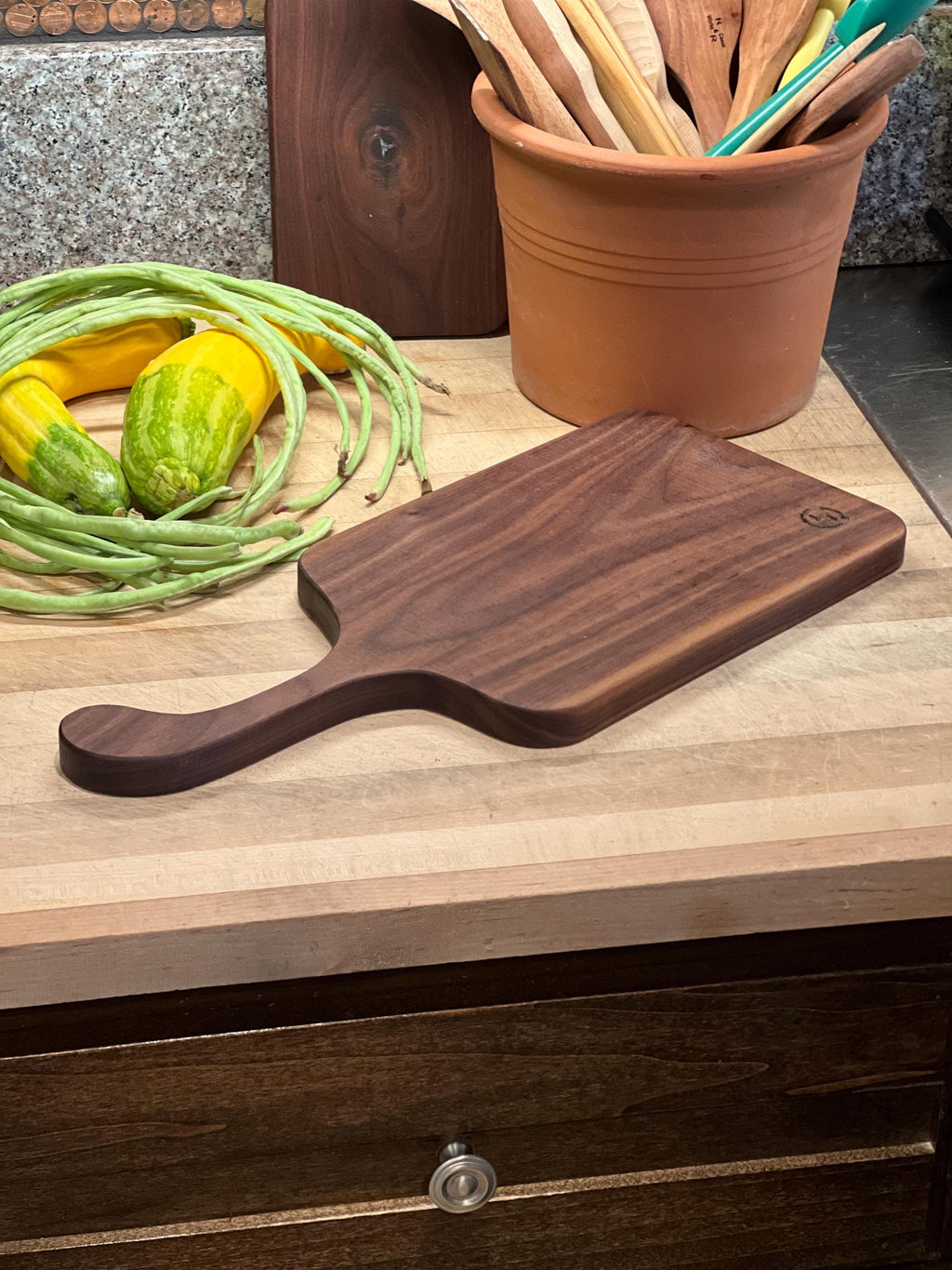 This is a handmade, solid wood walnut , custom design handle cutting board. The dimensions of this board are 17”x7 1/2”x3/4”.