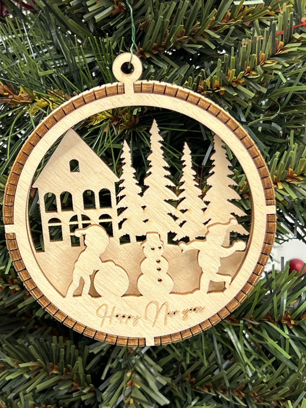 This is a round wooden Christmas ornament with a winter scene with a living hinge. It shows the kids having fun playing in the snow.